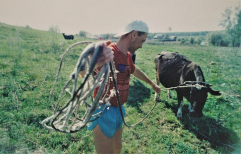 Мой папа держит на верёвке нашу корову Ночку.
