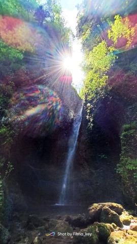 Маленький потайной водопад в лесу, лучи утреннего солнца создают волшебную лесную картину. 