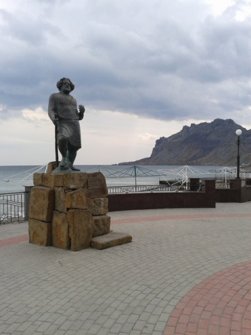 Памятник Максимилиану Волошину в Коктебеле на фоне пасмурного моря